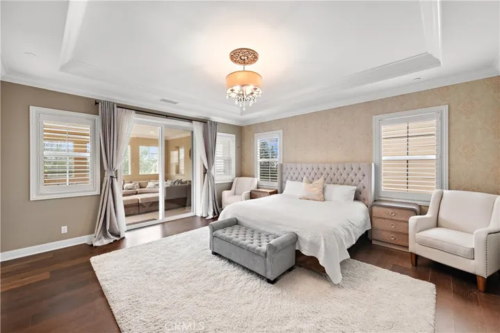 Primary bedroom with a private covered balcony overlooking the pool.