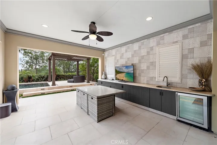 Covered California room with built-in cabinets and fridge.
