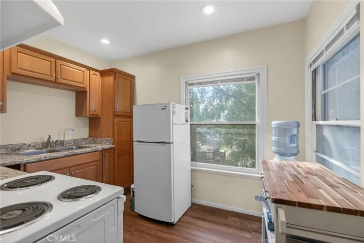 In the kitchen, there is a small refrigerator, a double sink, and room for storage.