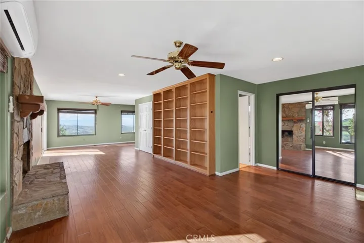 The primary suite features wood floors, plenty of light, and a fireplace.