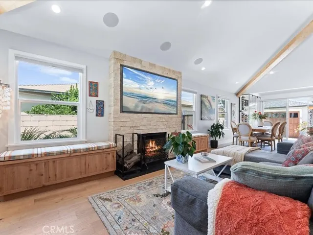 The family room  fireplace is bookended by cushioned sitting benches with storage below., beamed high ceilings Flush recessed lighting and zoned speakers throughout the home. Manufactured wood type plank flooring throughout.