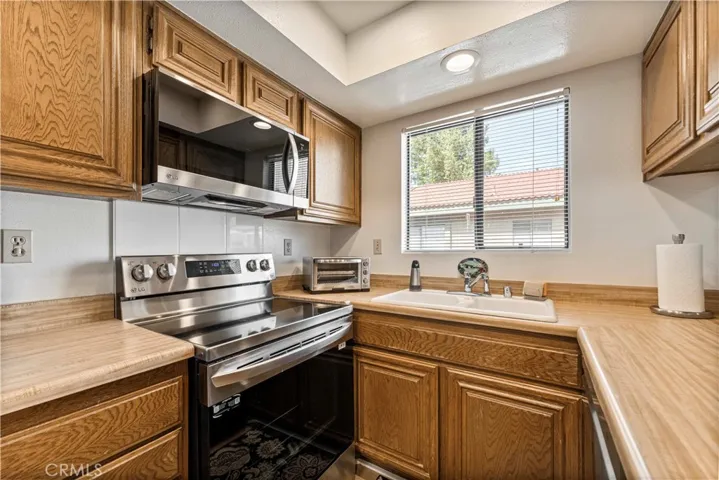 Super clean kitchen with newer stovetop range, microwave and refrigerator.