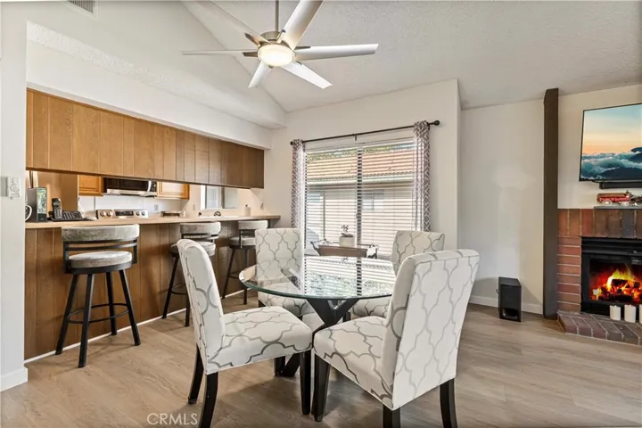 The bright dining area has a new ceiling fan and a cozy fireplace.