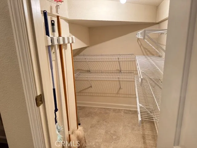 "L" shaped pantry under stairs with shelving