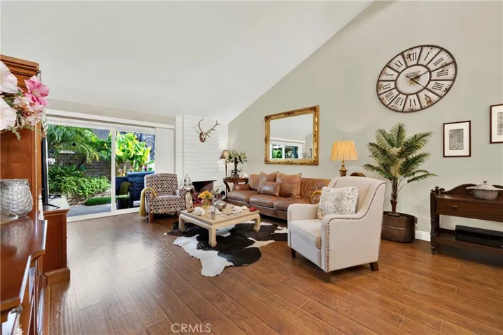Living area with fireplace high ceilings and natural light.