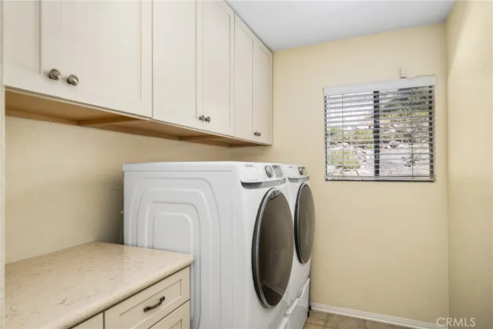 View of laundry room with ample storage and folding area
