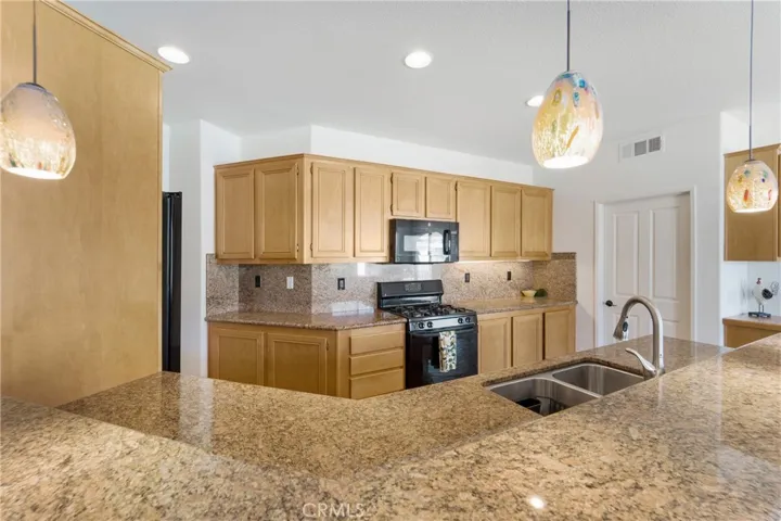 Granite laden counters and custom lighting grace this kitchen.