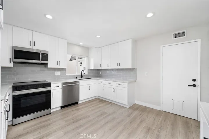 White shaker style cabinetry, quartz countertops, subway tile backsplash, matte black finishes and new stainless steel Samsung appliances!