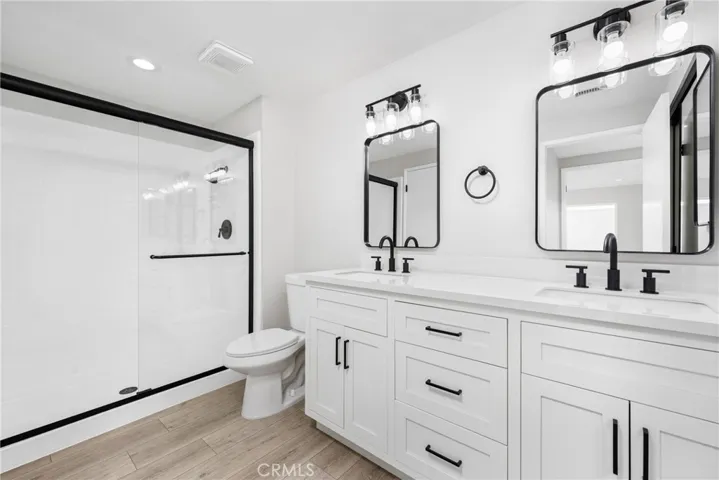 Enjoy dual vanity sinks and a glass enclosed walk-in shower