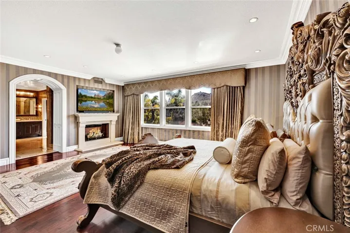 Another view of the owner's suite showing the doorway to the private bath and the fireplace with a custom mantle.