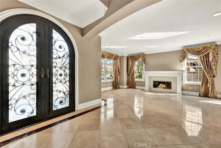 From the foyer looking into the formal living room with stoned faced fireplace and a custom mill work mantel.