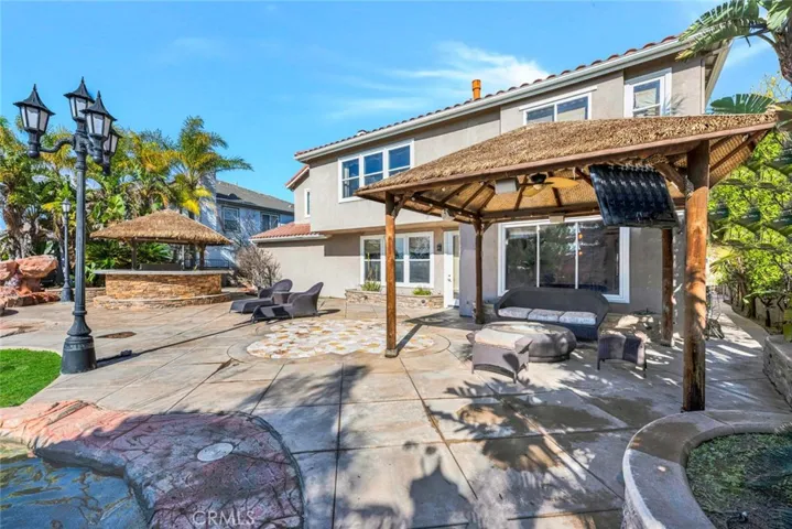 Another palapa houses the outdoor living area, with room for a furniture set and television underneath the ceiling fan.