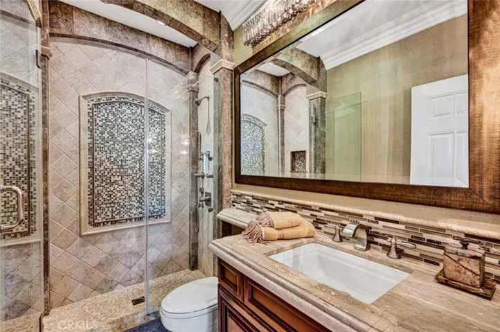 This is the ensuite bathroom for the bedroom you just viewed. It has a walk-in stone shower with rimless glass doors and it's own shower system.