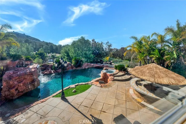 This shows the opposite side if the yard and the palapa that houses the outdoor kitchen. Near the right end of the pool you can see the bubbling open air spa.