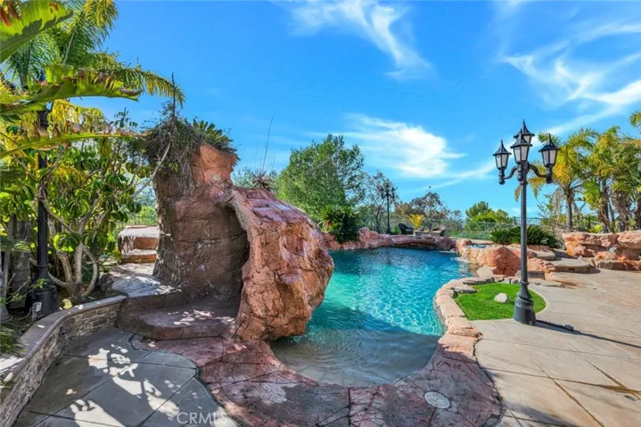 On the left in of the pool is a beach entry that's about 4' long. Beside that is the rock structure with the waterfall. And is that a doorway?