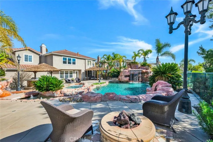 A view from the sitting area with a fire pit looking across the pool.