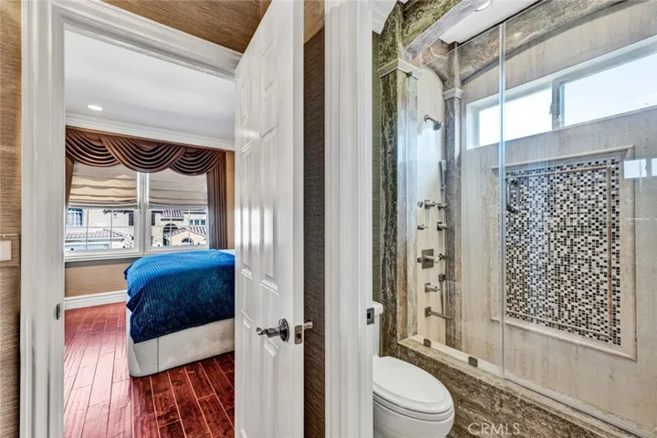 This view shows the tub/shower combo with it's own shower system and commode with privacy door.