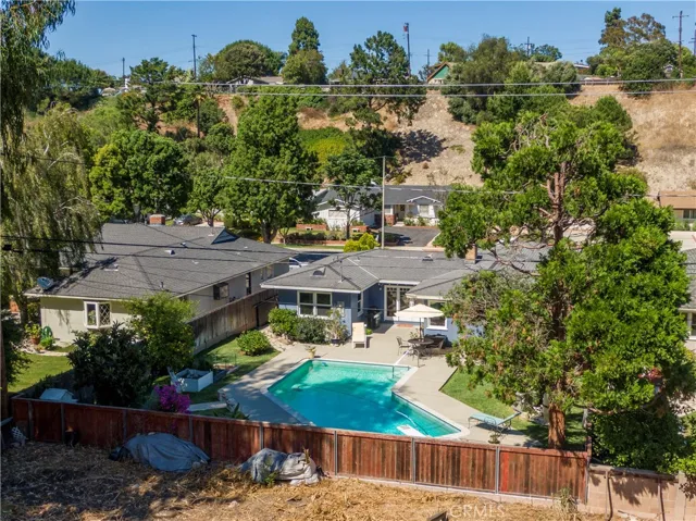 Aerial view of backyard and the back of the home. Lots of trees in the area