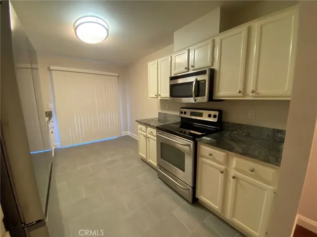 Kitchen with Tile flooring, electric stove and microwave