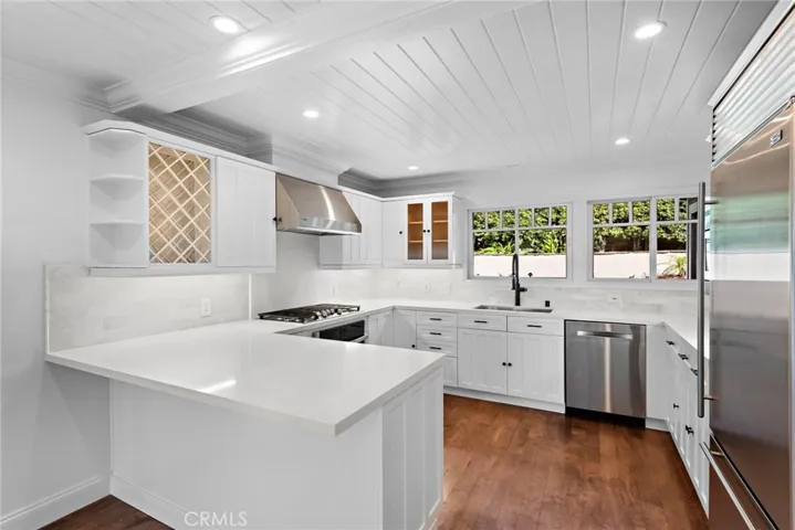Stunning remodeled kitchen boasting white cabinets, new counters, new sink/faucet and high end appliances.