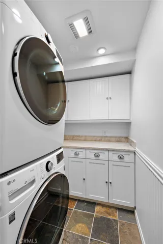 Interior laundry room with extra storage and folding counter.