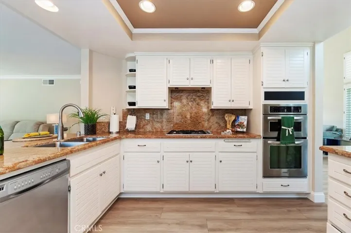 Ah, the gourmet kitchen features stainless steel appliances, Gas cooktop, microwave, oven, dishwasher, double sinks, and Beautiful granite countertops. Crown molding and recessed lighting