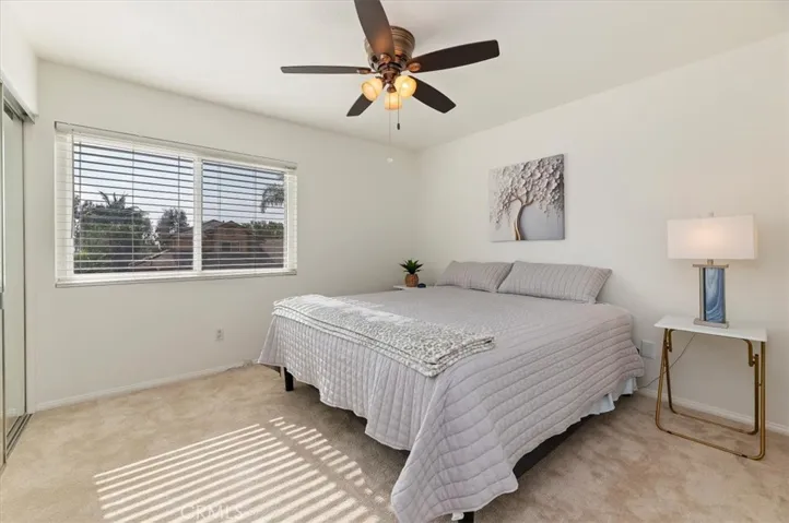 4th bedroom with large walk in closet with organizer and mirrored wardrobe doors. Freshly painted and new carpet. Ceiling fan. View out the front window of Hills and city lights