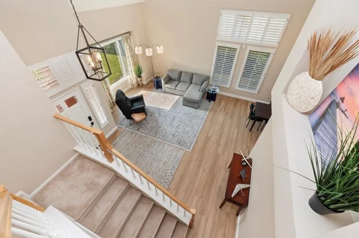 View from the upper landing into the living room and foyer. Lots of natural lighting and neutral colors, notice the new carpet