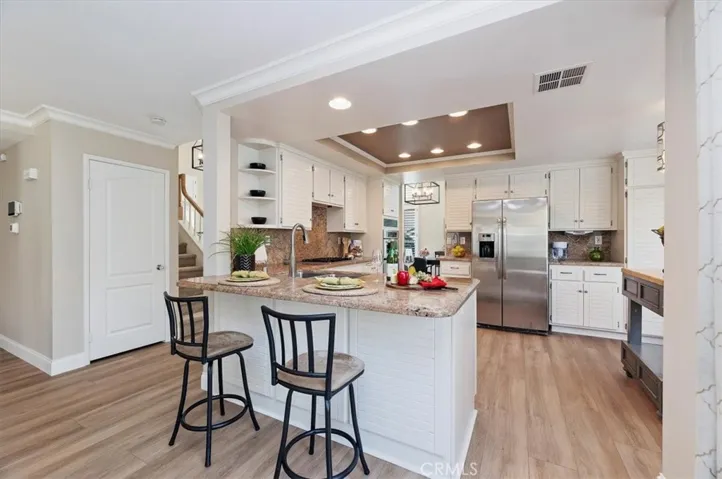 Breakfast bar perfect for informal eating. Notice the crown moldings, large baseboards and recessed lighting