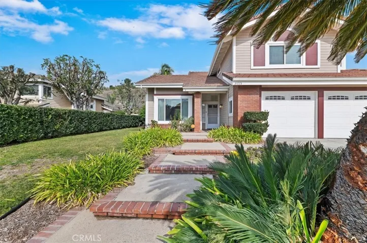 View of the front. Lush landscaping and also rain gutters.