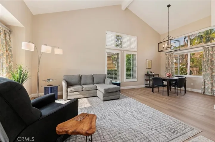 View from foyer into living room and dining room. Notice the large picture window in dining room which over looks a shade garden and pool & spa