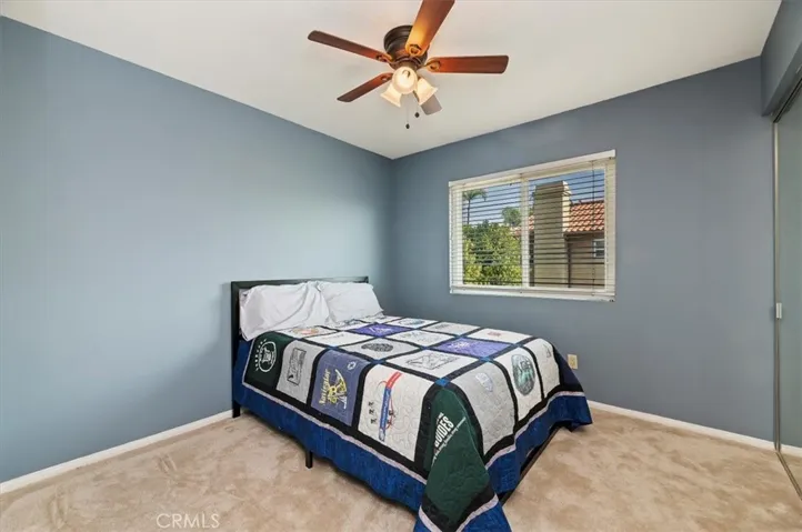 Large secondary bedroom with wooden blinds, closet with organizer and mirrored wardrobe doors. New carpet