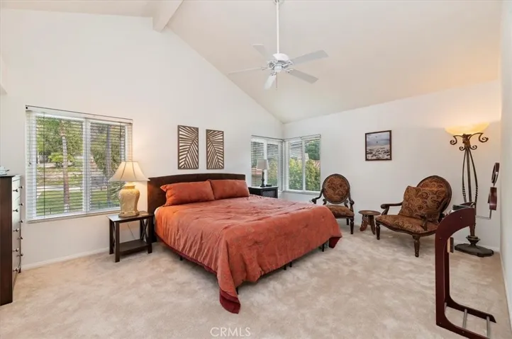 Step through double door entry to the primary bedroom with vaulted ceiling and ceiling fan. Notice the windows have views of backyard and hills. Freshly painted and new carpet