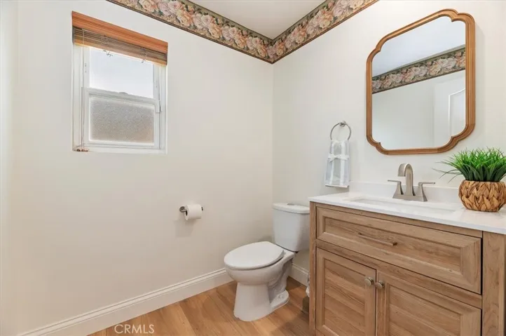 Powder room with updated vanity, mirror and wooden blinds