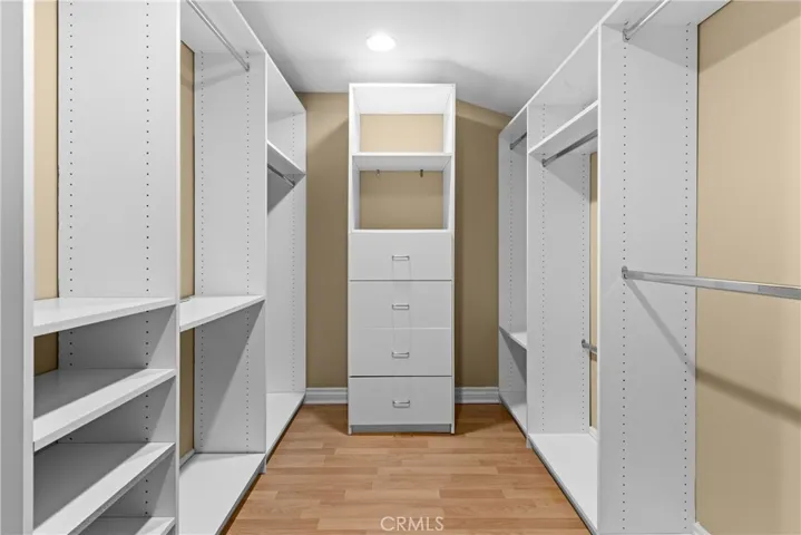 Primary bedroom walk in closet with organizer