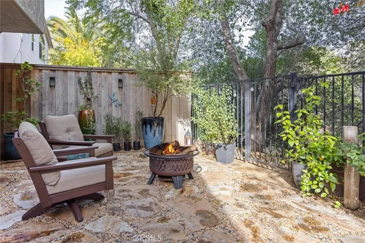 Additional space for outdoor living. Sip your favorite beverage by the firepit. The gate in the fence allows for access to maintain foliage as needed outside the patio.