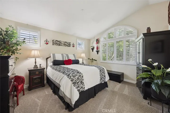 The primary bedroom with newer carpet and lovely views of the backyard.