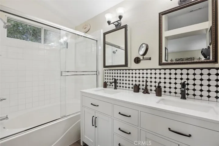 Double sinks and soaking tub with tile surround.
