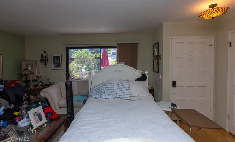 Look past the bedroom furniture and see the large sliding door to the patio