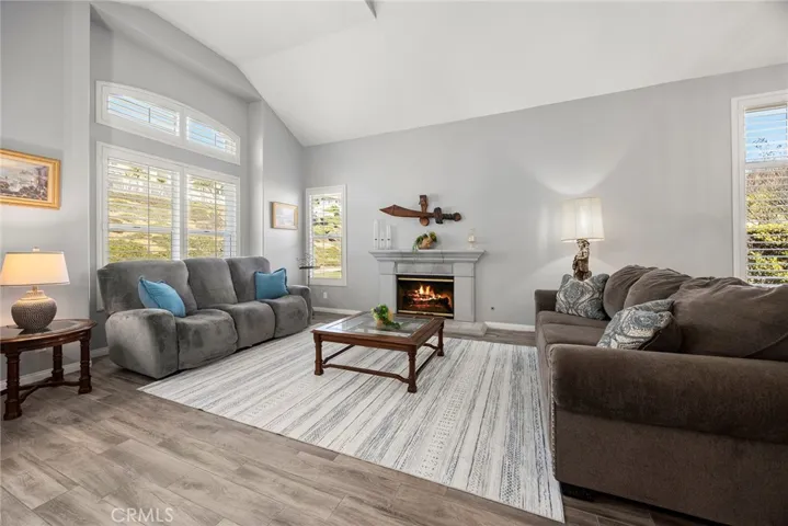 Open Formal Living Room with fireplace and plantation shutters.