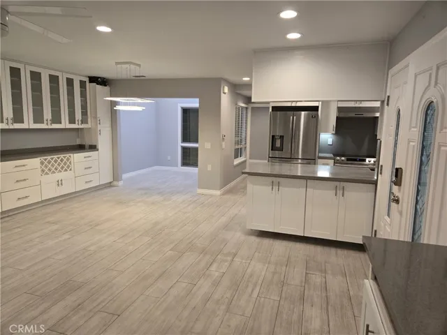 View from corner of living room showing dining/enclosed atrium/kitchen