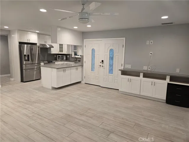 Entryway flanked by kitchen and living room built-ins