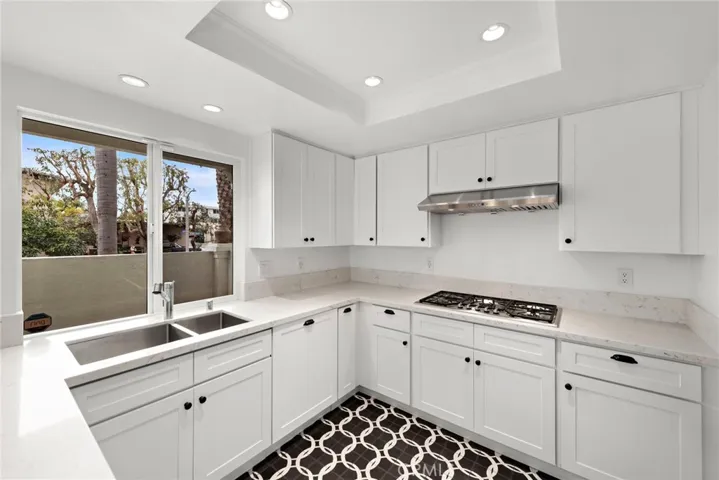 View from light and bright kitchen to large patio. Quartz counters. Stainless sinks.