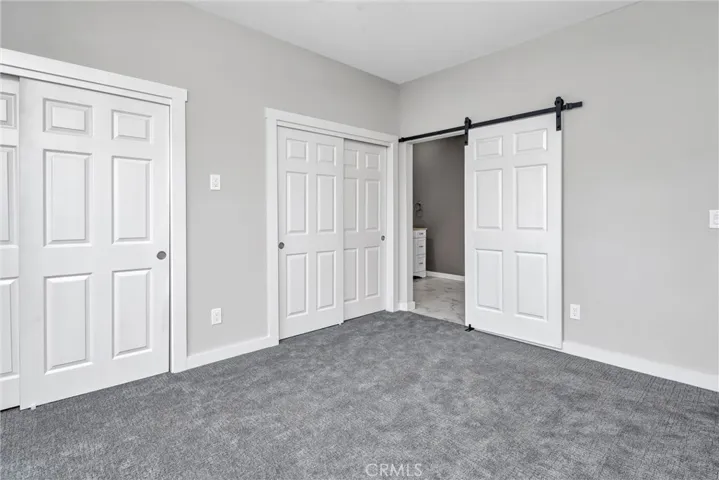 Two closets and a barn door to the bathroom