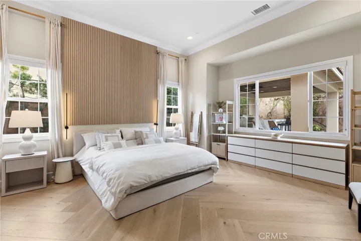 Master bedroom retreat with custom remote controlled blinds and real hardwood floors