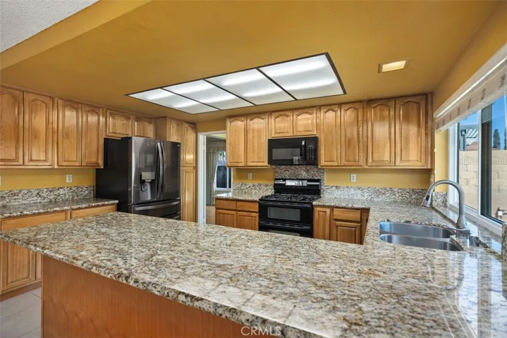 Lots of beautiful cabinets for storage and granite countertops.