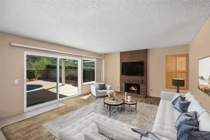 Enjoy the spacious Family Room with the cozy fireplace & large double pane slider and window.
Note: This photo is virtually staged.