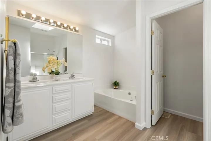 Primary en-suite bathroom w/ skylight is light and bright
