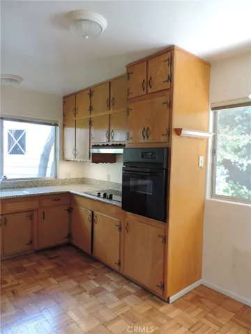 Main Floor Kitchen Area with Vintage Cabinetry, Electric Cooktop, and Single Oven