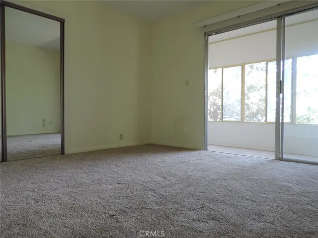 Lower Floor Master Bedroom Area with Mirrored Wardrobe Closet and Direct Access to Enclosed Porch Area